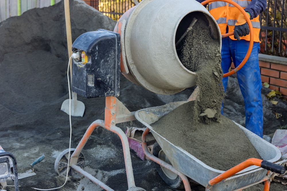 Preparation installation in progress with mixing a sandy base for stone bricks paved sidewalk near street the city