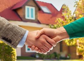 close-up-of-handshake-with-house-for-sale-in-background-free-photo